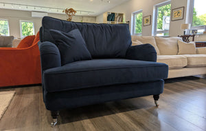 Navy blue sofa in a living room with other furniture and decor.