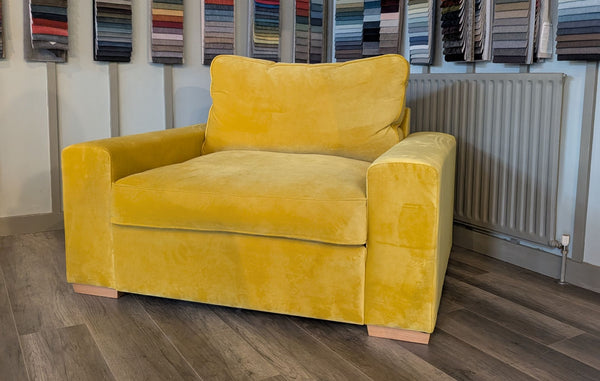 Yellow armchair in a room with patterned wallpaper and a radiator.